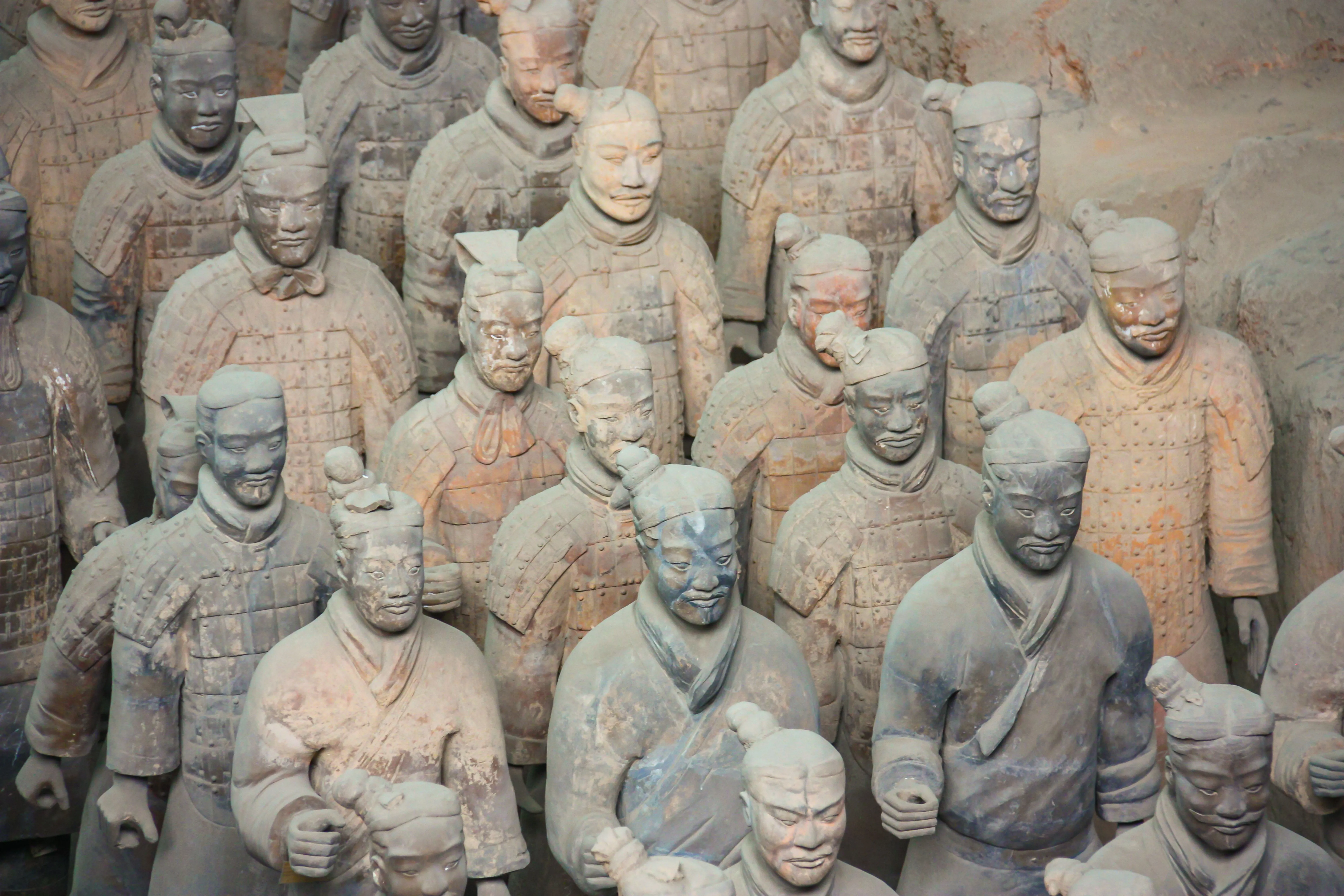 Rows of Terracotta Army figures in the excavation pit at Xi'an, with traces of the original paint still visible
