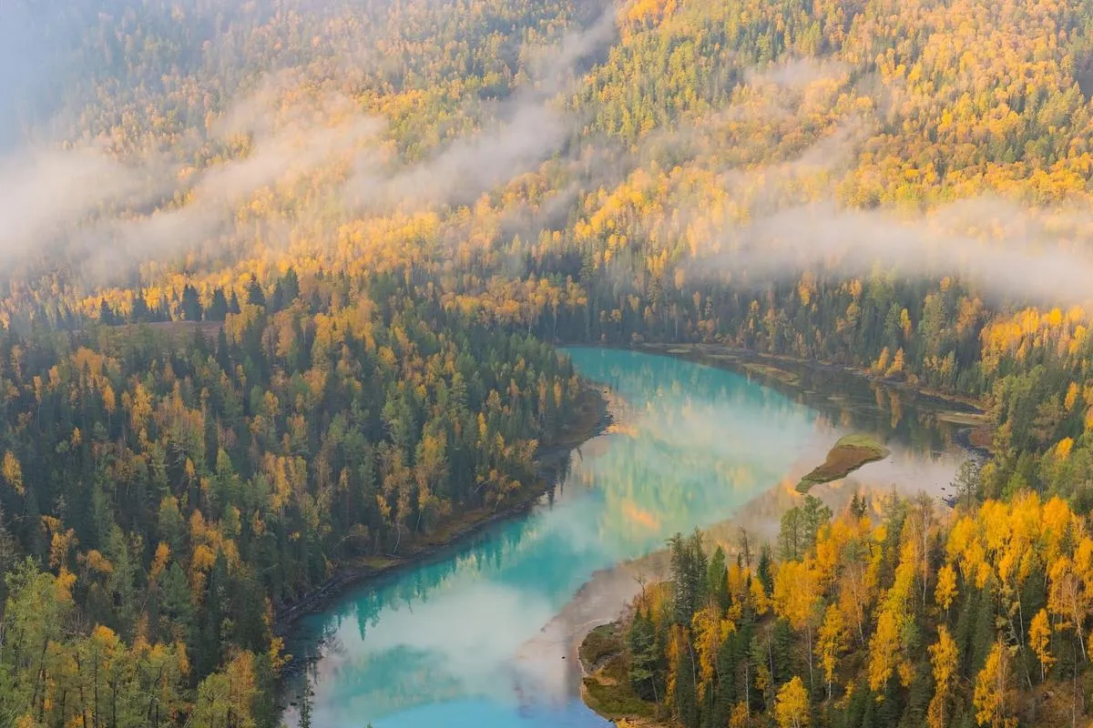 Morning mist over an autumn valley in Kanas