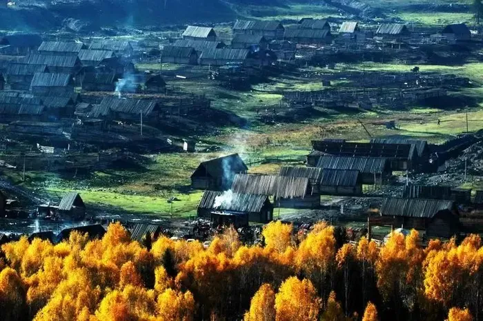 Hemu village at dawn, mist over Tuva log houses