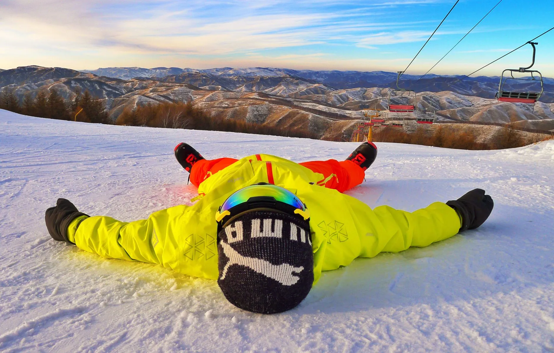 Skier in bright winter gear on a snowy mountain slope