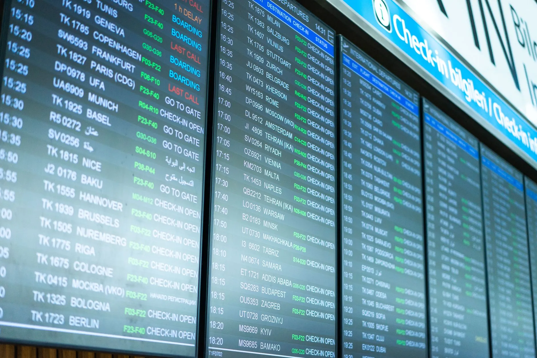 A digital flight information board inside an airport terminal