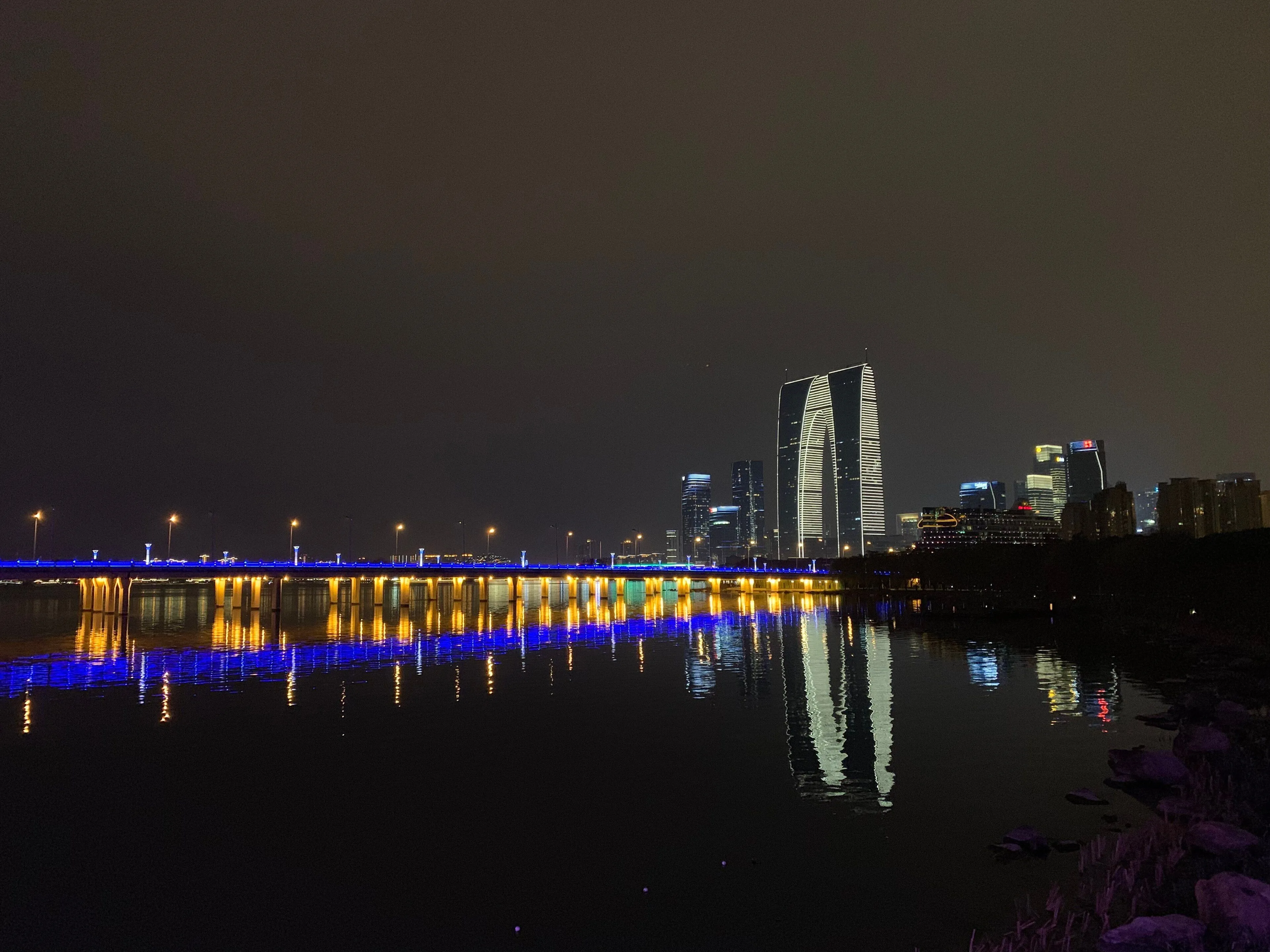 The Gate of the East lit up at night across Jinji Lake
