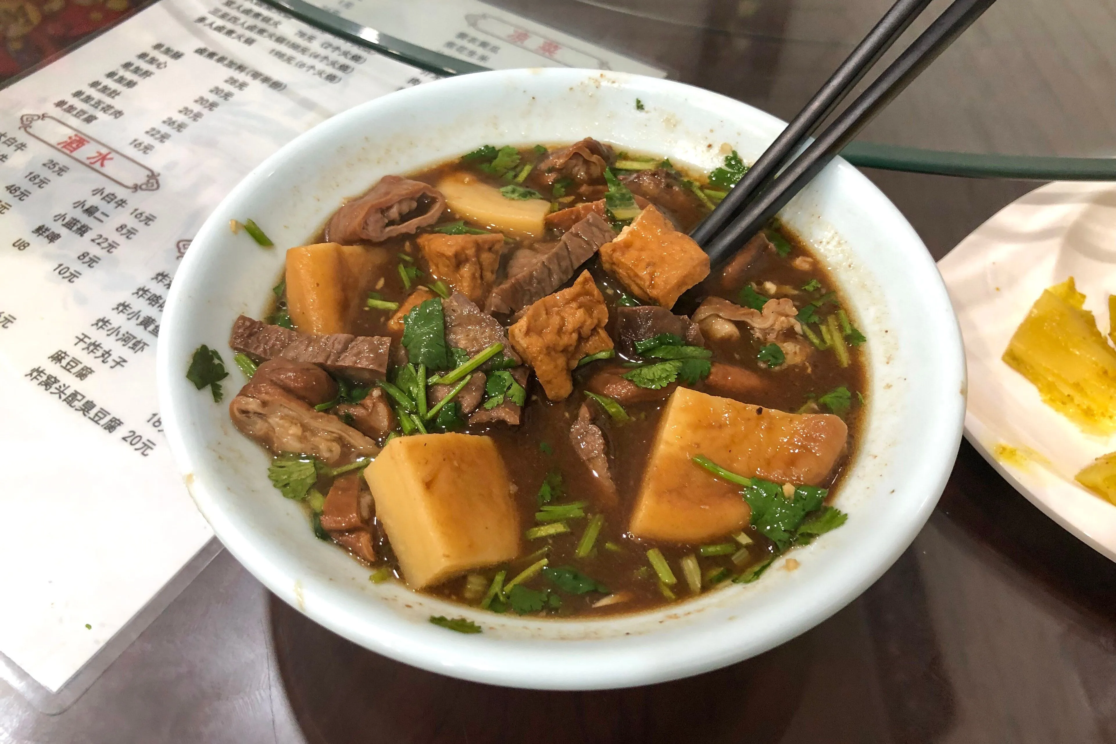 Luzhu huoshao — stewed offal with a hard wheat cake, Beijing's most confrontational snack