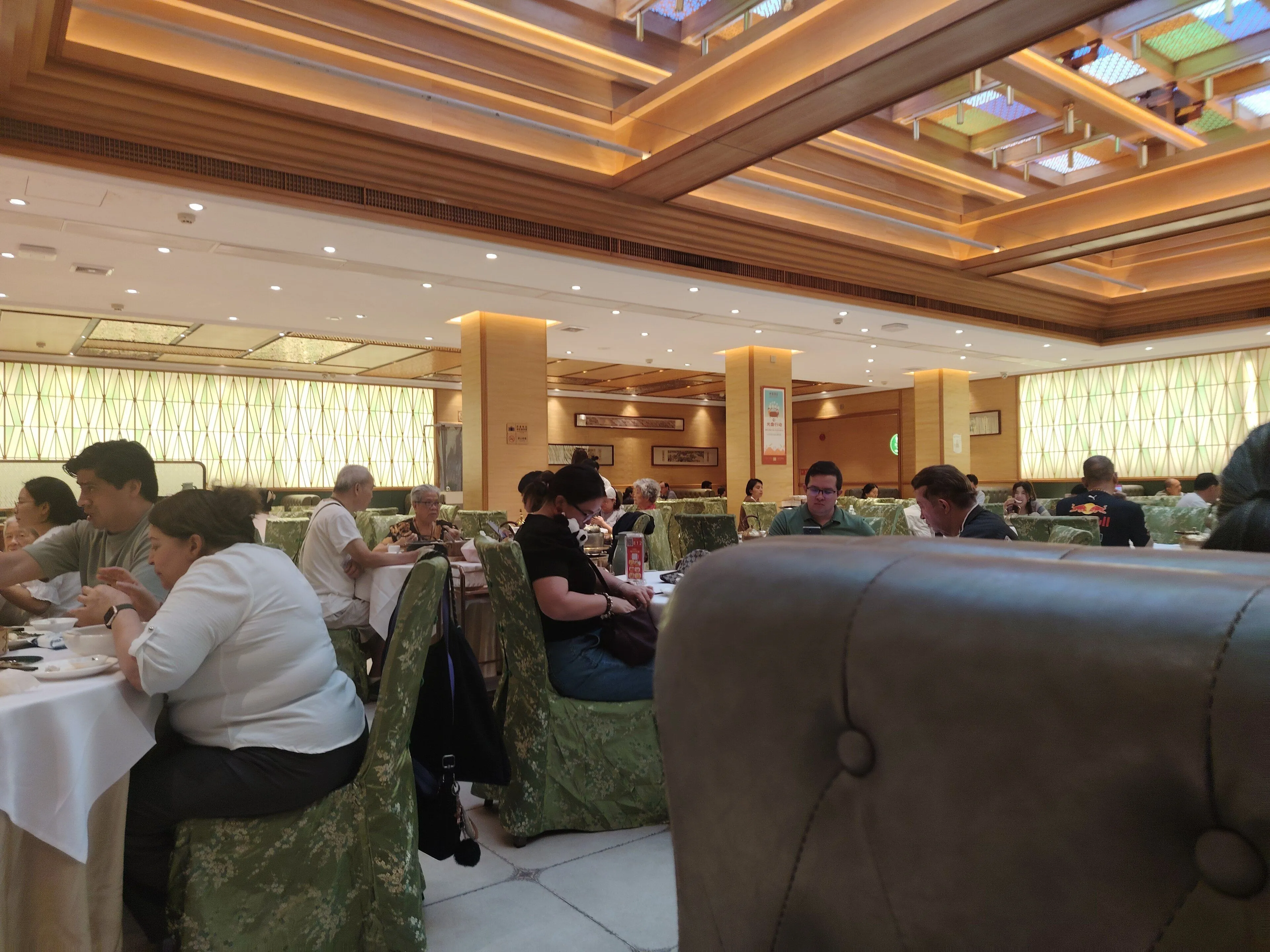 Diners at round tables in a Cantonese teahouse dining hall, Guangzhou