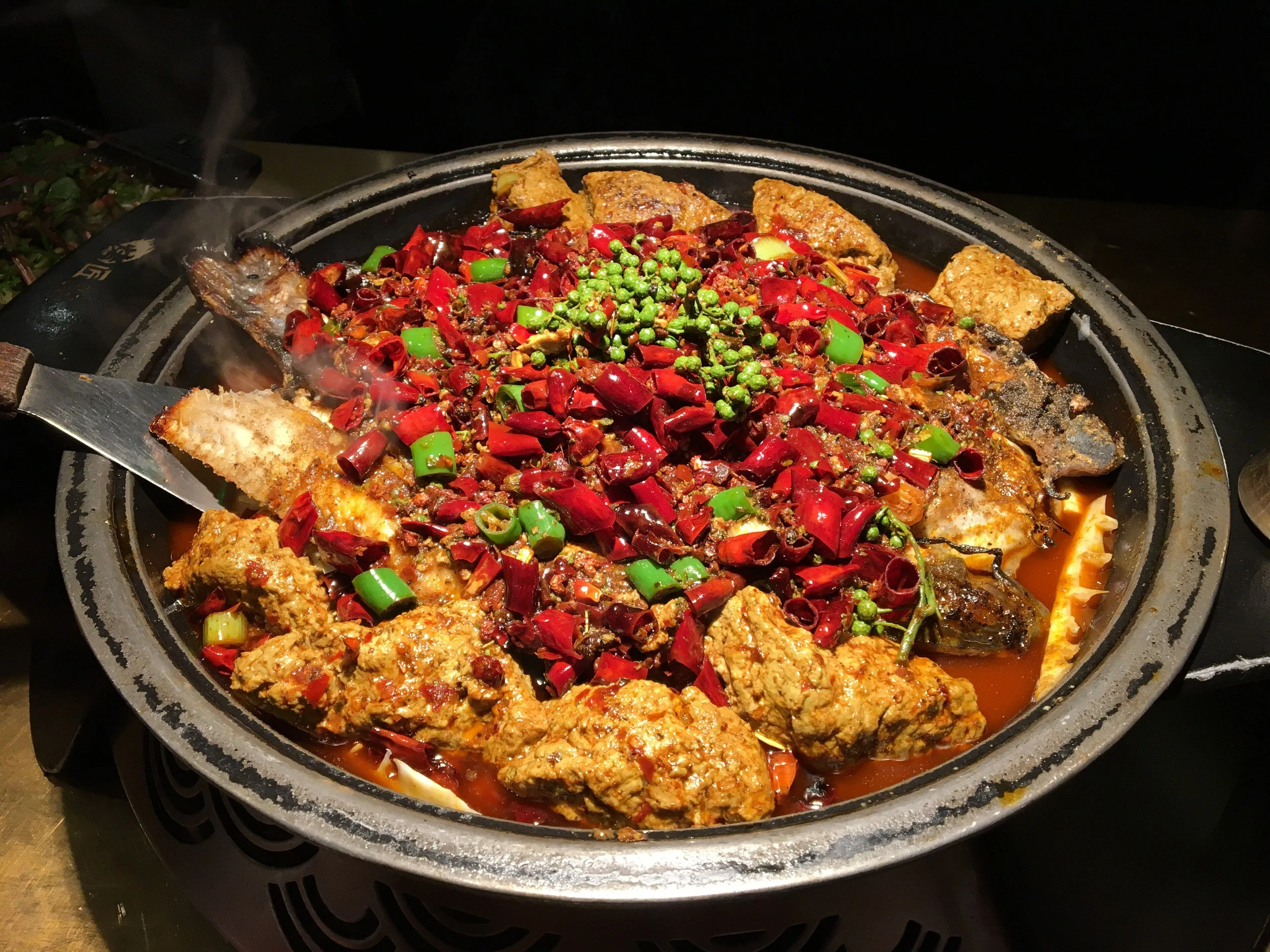 Wanzhou kaoyu — charcoal-grilled fish finished in a tallow-and-chilli base, Chongqing