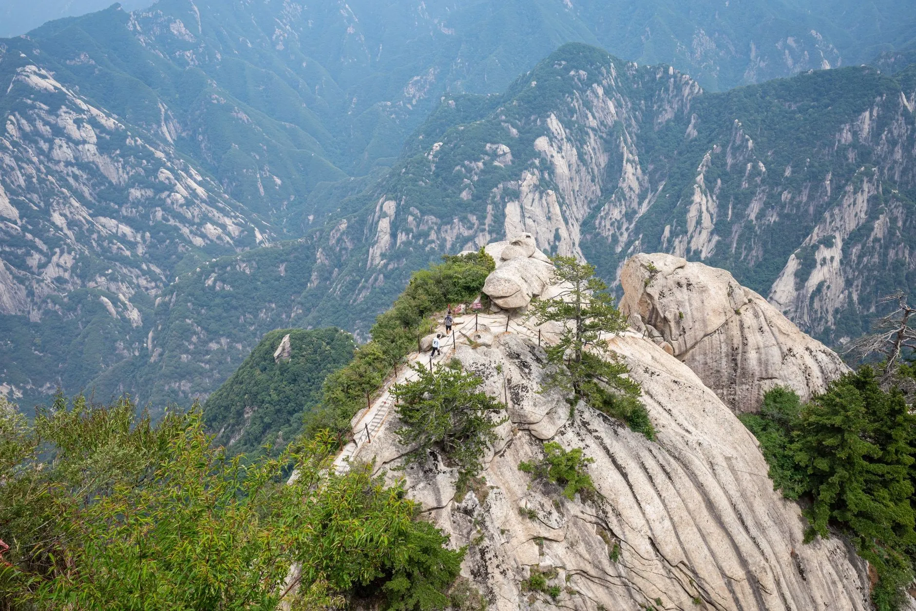 Huashan cliff-edge narrow trail with hikers holding chains