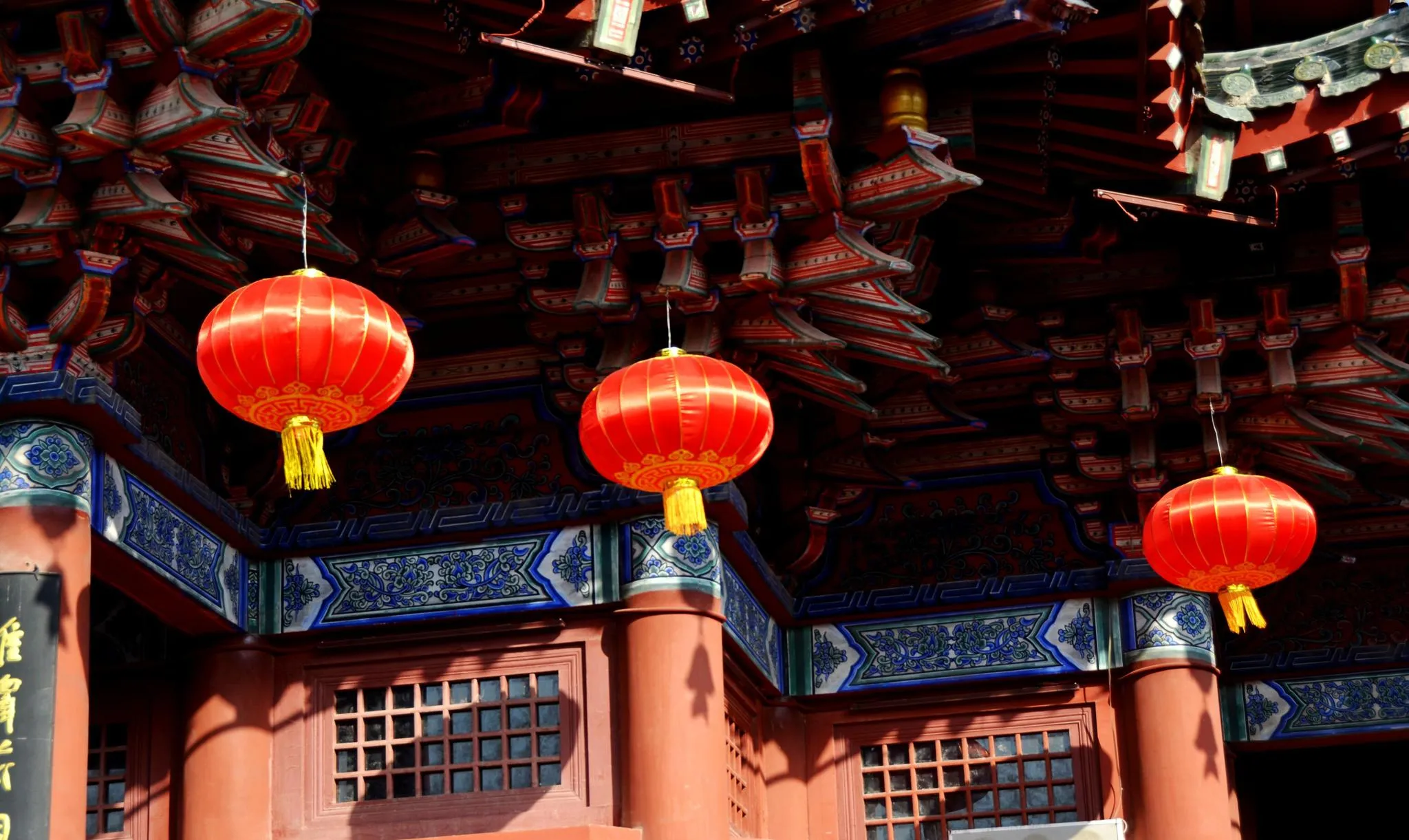 Red lanterns hanging under a temple eave during Chinese New Year