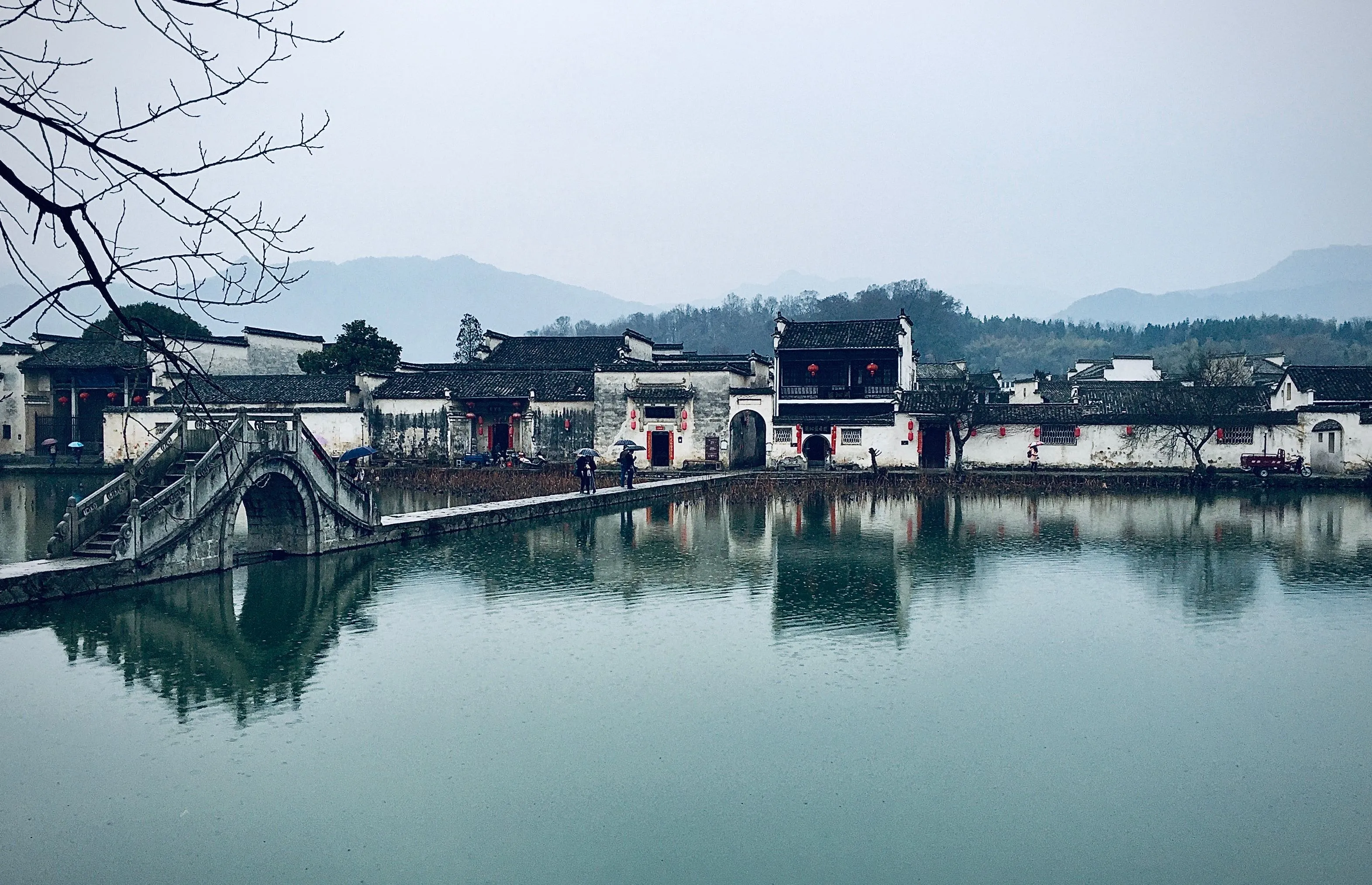 The whitewashed walls, grey roofs and stepped horse-head walls of the Huizhou village of Hongcun, reflected in a pond