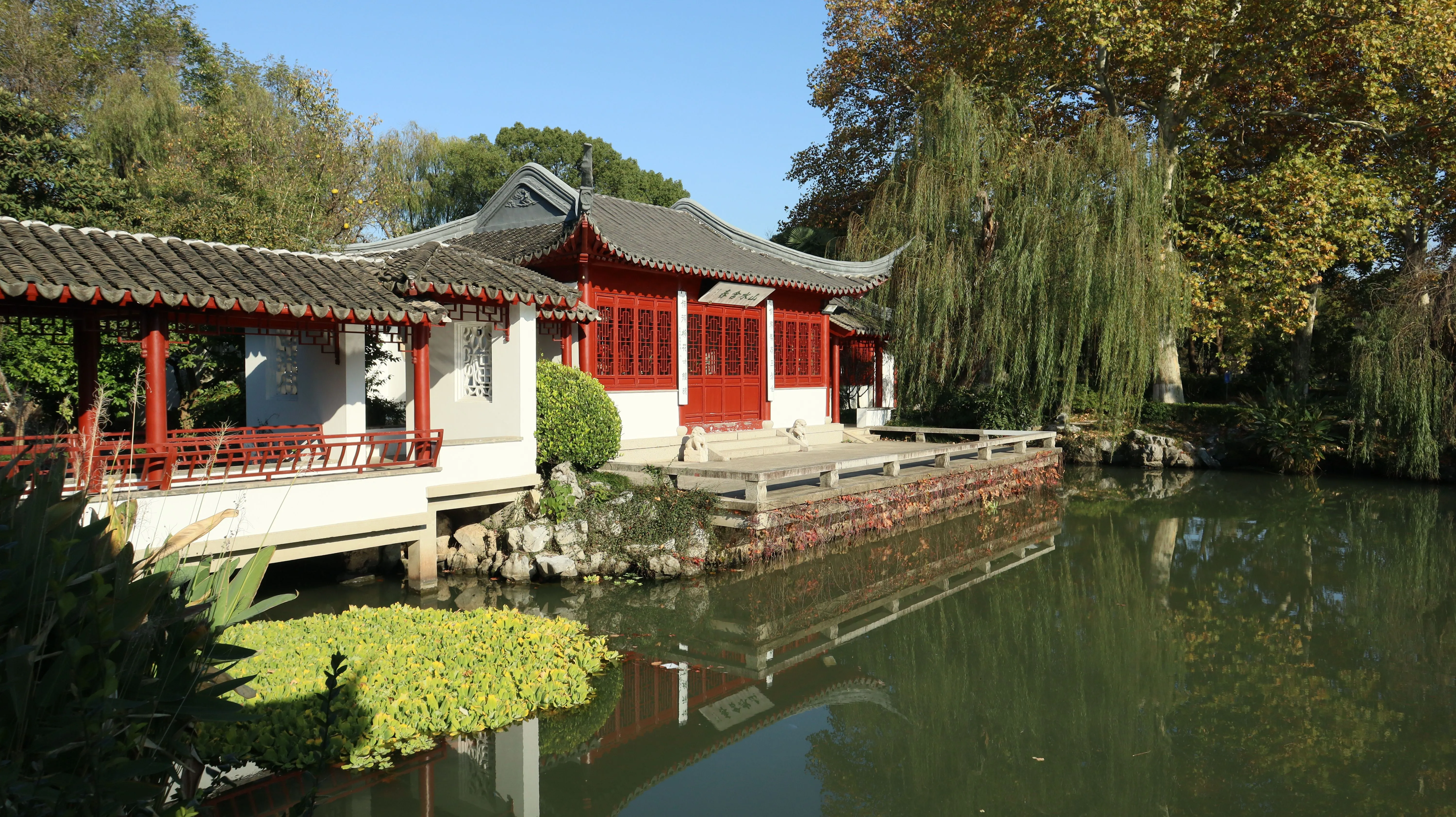 A winding covered corridor beside a pond in a classical Suzhou garden