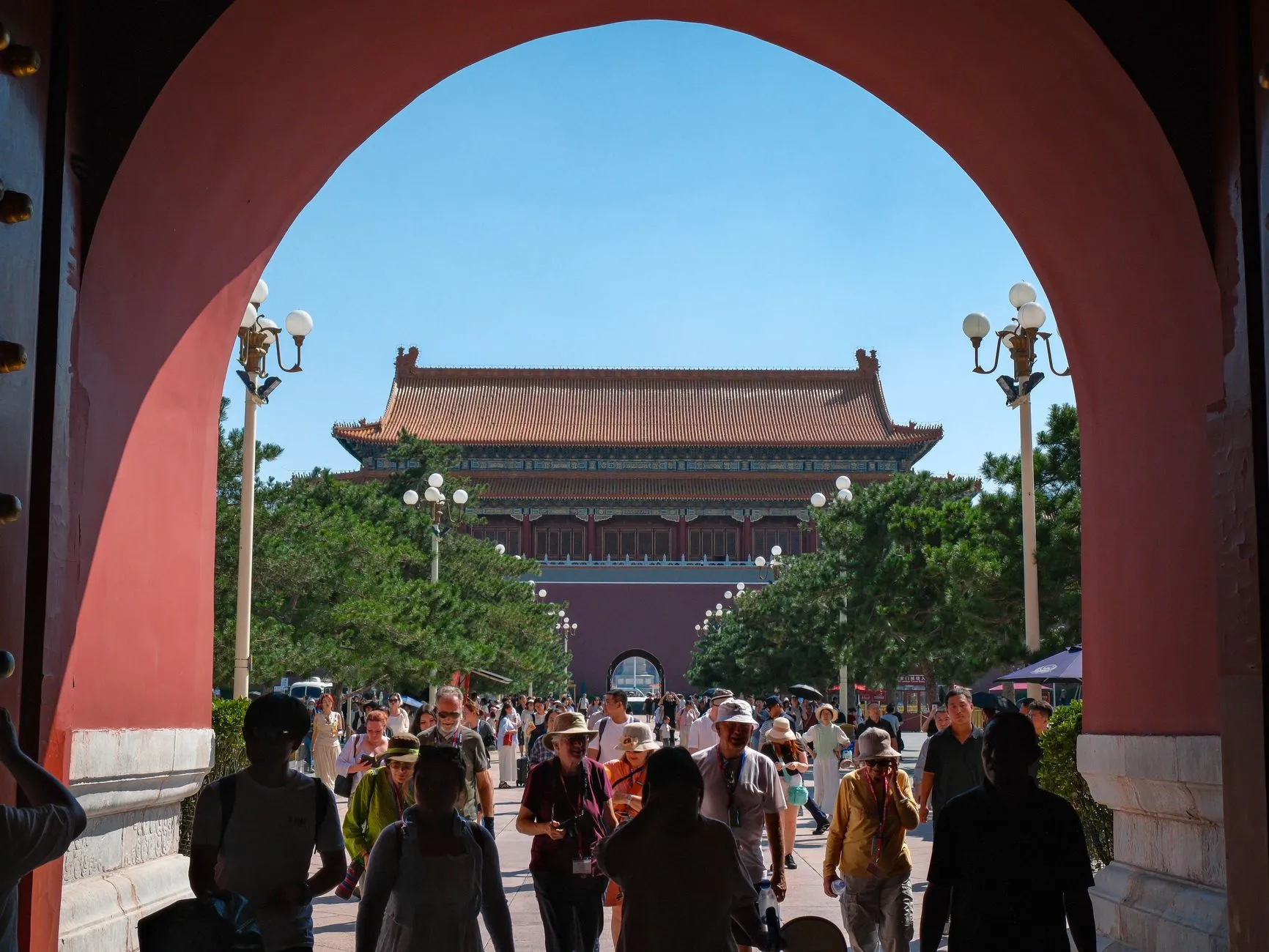 Visitors walking through the Meridian Gate archway at the Forbidden City, Beijing