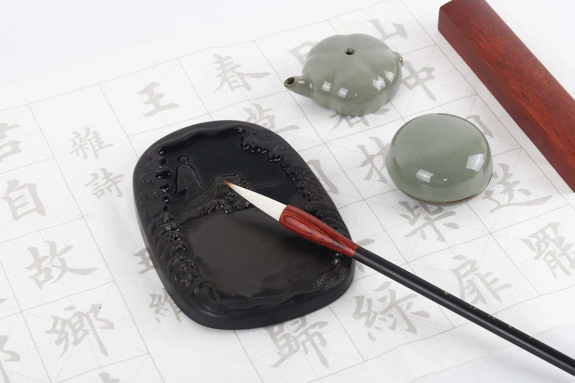 A Duan inkstone and brush resting on a sheet of model regular-script characters