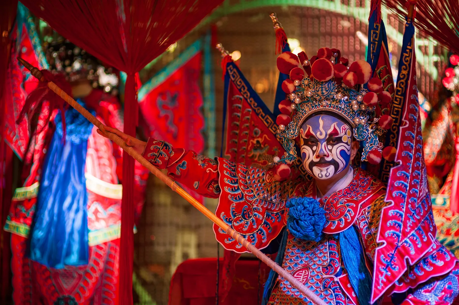 A Peking opera general in a painted face, four back-banners and a red robe