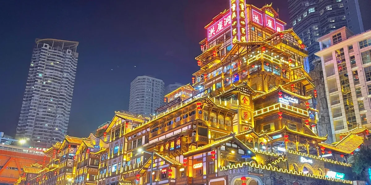 Hongya Cave illuminated at night above the Jialing River